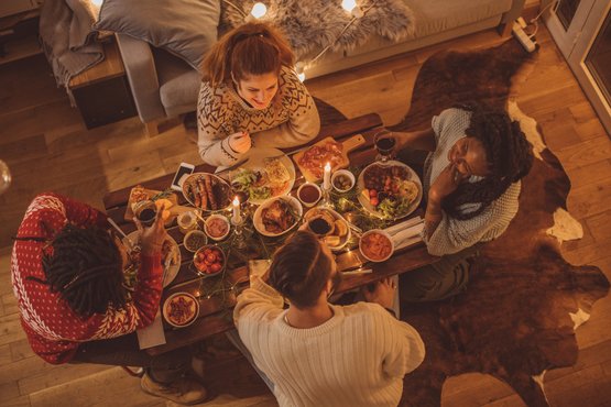 Vier Personen sitzen an einem Tisch zum Weihnachtsessen