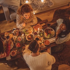 Vier Personen sitzen an einem Tisch zum Weihnachtsessen