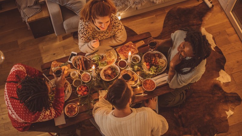 Vier Personen sitzen an einem Tisch zum Weihnachtsessen