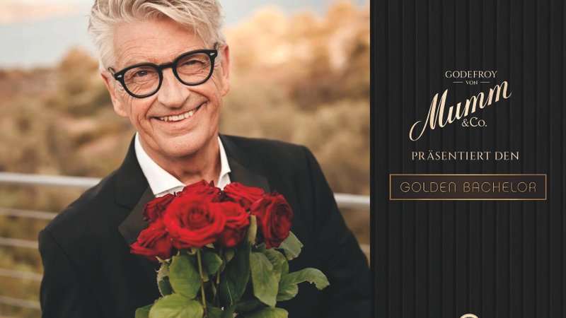 Der "Golden Bachelor" mit einem Strauß Rosen und dem Logo Godefroy von Mumm